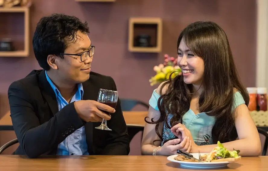 Jeune couple souriant au restaurant