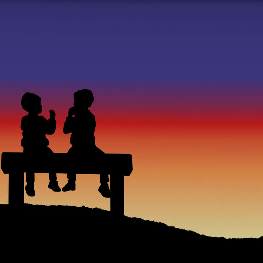 Deux enfants parlent assis devant un coucher de soleil.