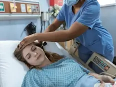 Une infirmière prend la température d’une dame hospitalisée.